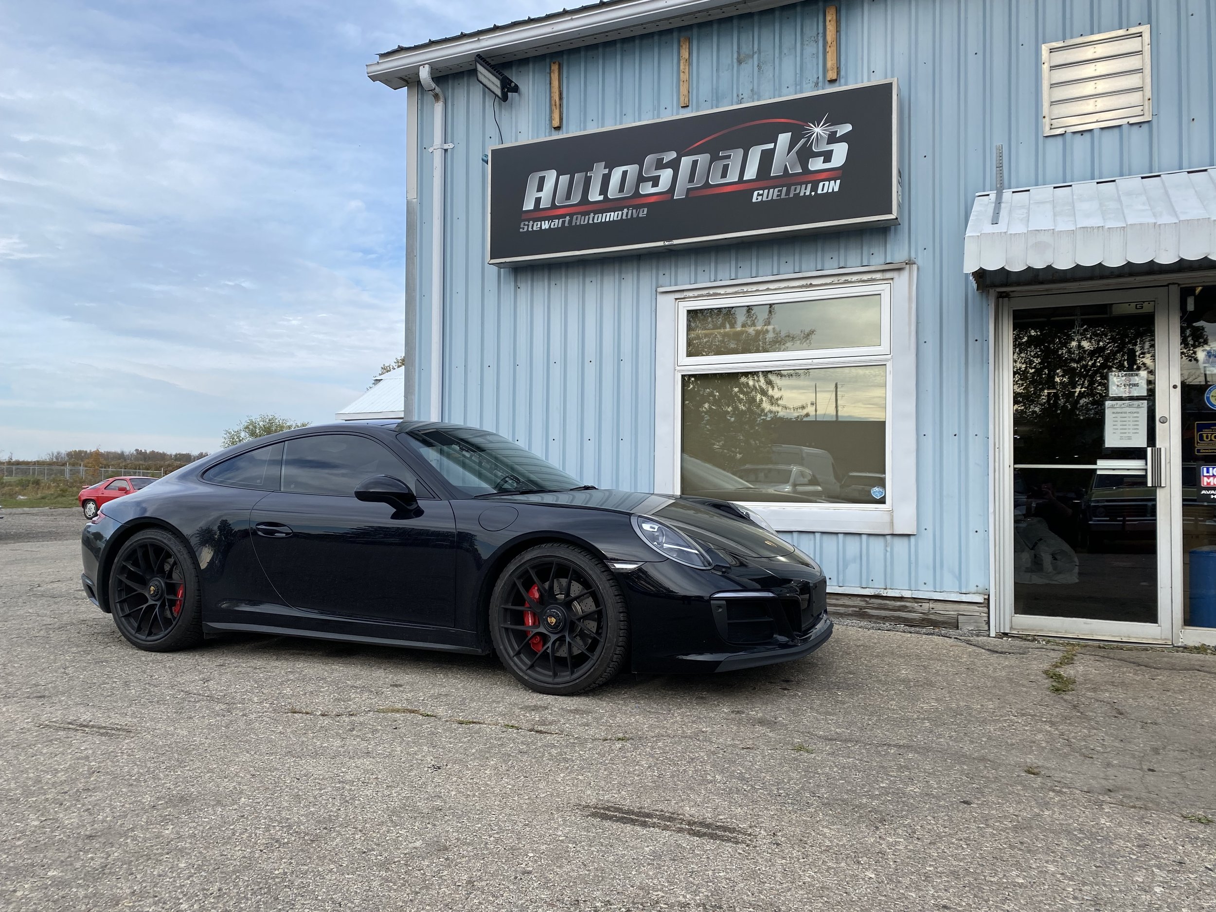 Black sports car in front of the AutosparkS building