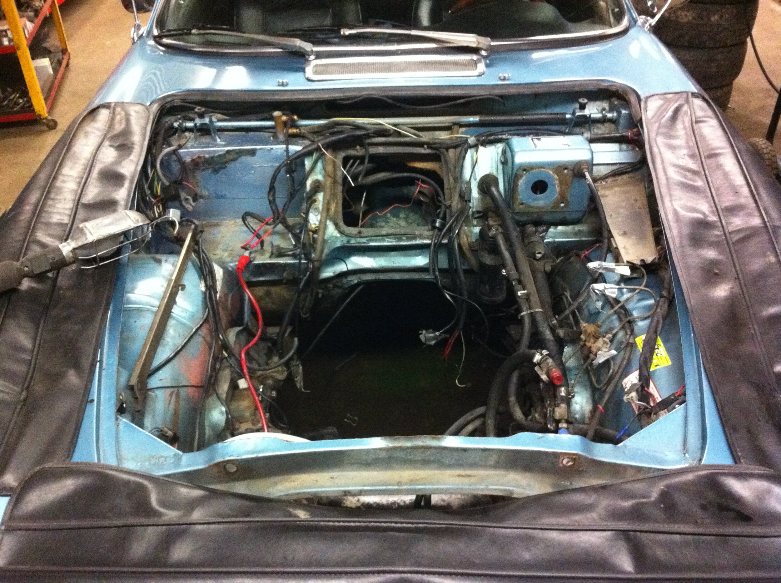 Engine bay stripped open — restoration project on the lift