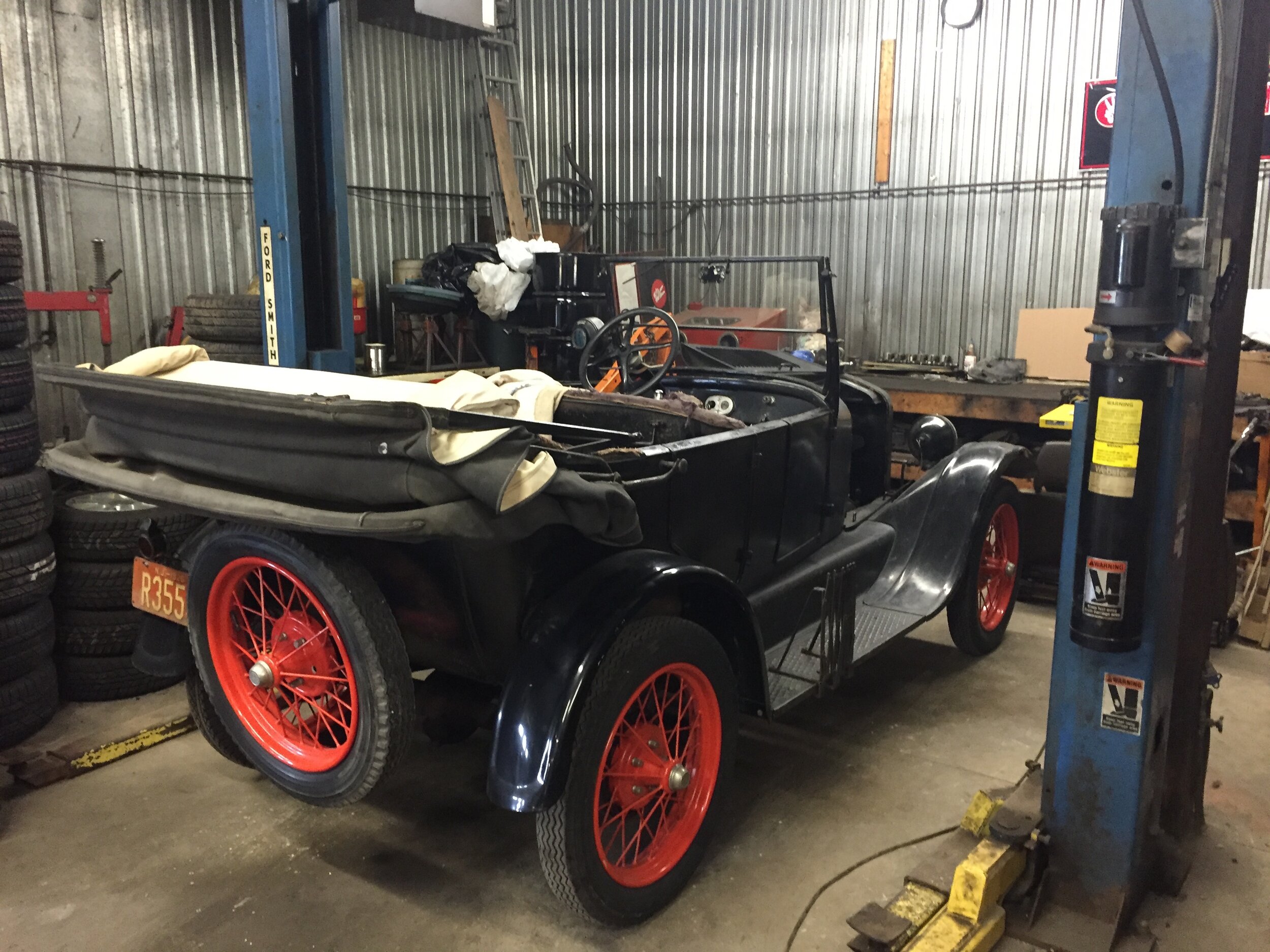 Vintage black car with red wheels inside the garage